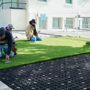installer using a stake to secure turf
